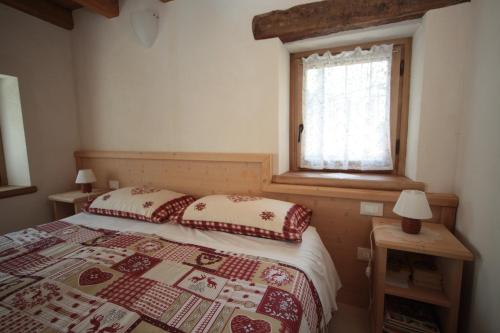 een slaapkamer met een bed en een raam bij Albergo Diffuso Valcellina e Val Vajont in Casso in Casso