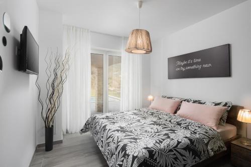 a bedroom with a black and white bed with pink pillows at Villa Terra in Labin