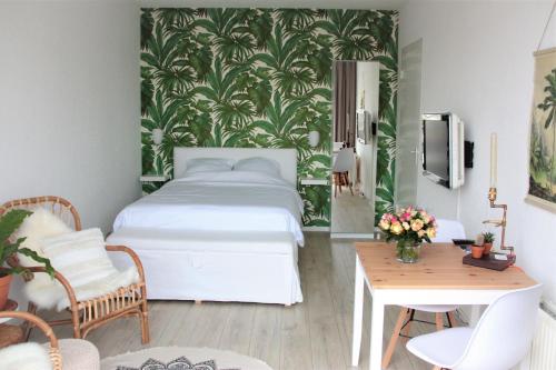 1 dormitorio con cama, escritorio y mesa con sidx de mesa en De Grutter, en Zandvoort