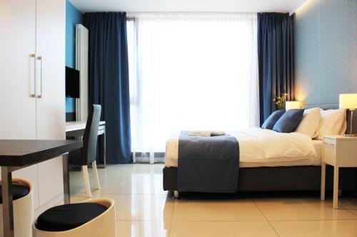 sypialnia z łóżkiem z biurkiem i oknem w obiekcie JessApart – Ochota Apartments w Warszawie
