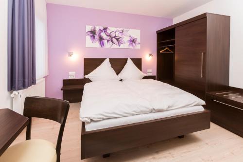 1 dormitorio con 1 cama grande y paredes moradas en Gasthof im Almetal, en Büren