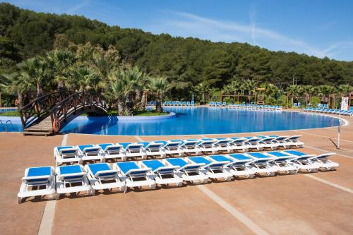 a group of lounge chairs in front of a swimming pool at Camping Torre de la Mora in Tamarit