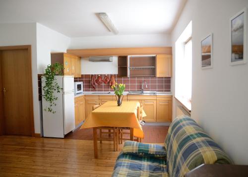 a kitchen with a table and a couch at Casa vacanze Dos de Loré - Relax a due passi da Tovel in Tuenno