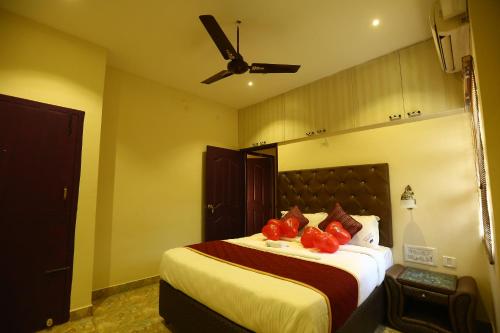 a bedroom with a bed with red pillows on it at Zingle Stay Airport Hotel in Chennai