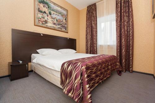 een hotelkamer met een bed en een raam bij Regina na Universitetskoy in Kazan