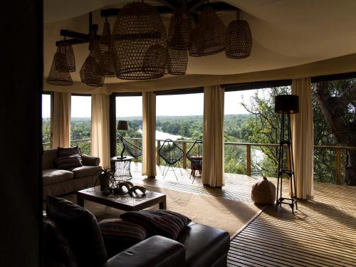 a living room with a couch and a large window at Simbavati Hilltop Lodge in Timbavati Game Reserve