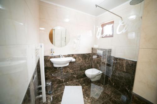 a bathroom with a sink toilet and a mirror at Guest House Ćiro in Sarajevo