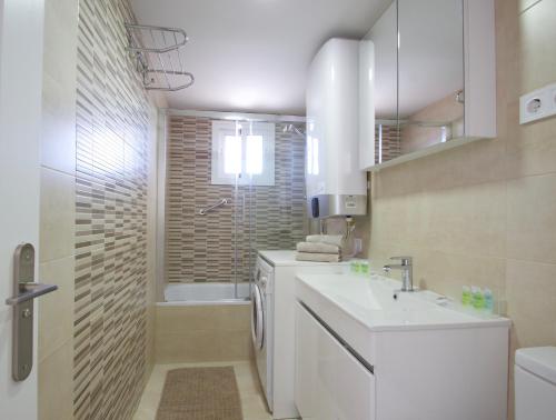 a white bathroom with a sink and a shower at R&E apartment in Torremolinos