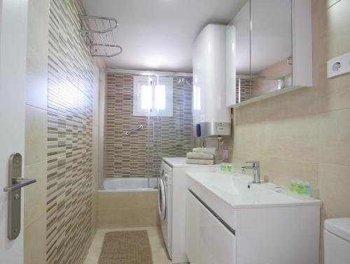 biała łazienka z umywalką i prysznicem w obiekcie R&E apartment w mieście Torremolinos