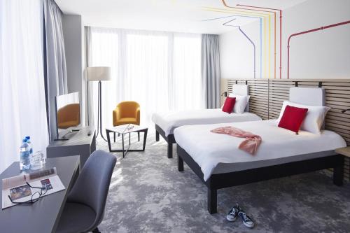 a hotel room with two beds and a television at ibis Styles Warszawa City in Warsaw