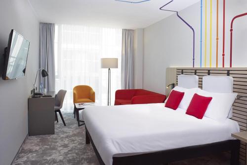 a hotel room with a bed with red pillows at ibis Styles Warszawa City in Warsaw