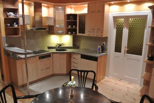 a kitchen with wooden cabinets and a table in it at Penzion Valkoun-Lilienfeld in Karlovy Vary