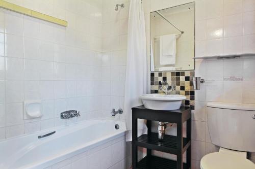 uma casa de banho com um lavatório, um WC e uma banheira em Baywater Village em Sedgefield