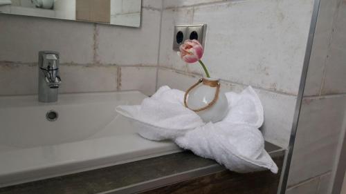 a vase with a pink flower sitting on a sink at Gästehaus Strausberg in Strausberg