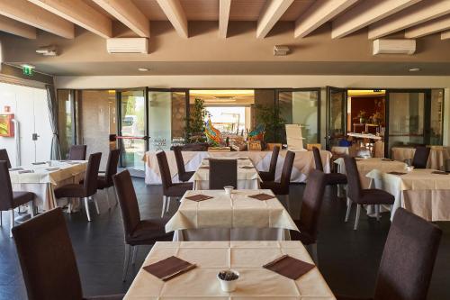 a dining room with tables and chairs and a restaurant at Hotel Resort Villa Luisa & Spa in San Felice del Benaco