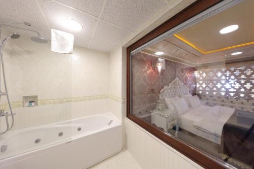a bathroom with a tub and a bed and a window at Deluxe Golden Horn Sultanahmet Hotel in Istanbul