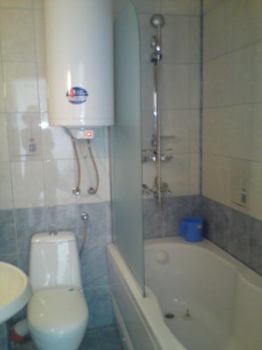 a bathroom with a toilet and a tub and a sink at Villa Visoka in Balchik