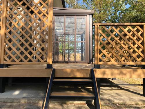 a screened in porch with a bench and a window at Minpaku Momotaro Bekkan in Kasugai