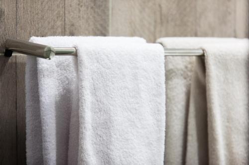 a group of white towels hanging on a towel rack at Hôtel des Beaux Arts in Chambéry