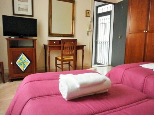 a living room with a pink couch and a table at I Cappuccini Rooms in Catania