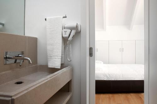 a bathroom with a sink and a phone at Lisbon Serviced Apartments - Baixa in Lisbon