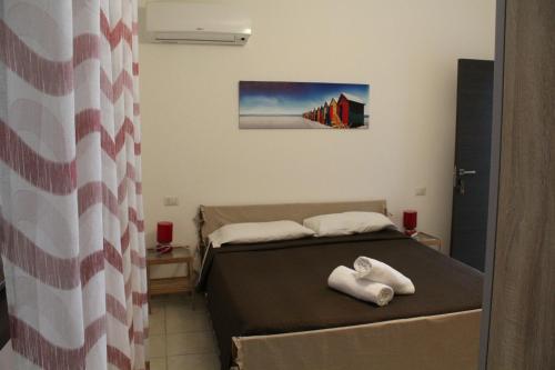 a bedroom with two beds with towels on the bed at Affittacamere la Medusa in Porto Pino