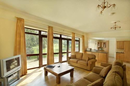 a living room with a couch and a coffee table at Godshill Park Cottages in Godshill