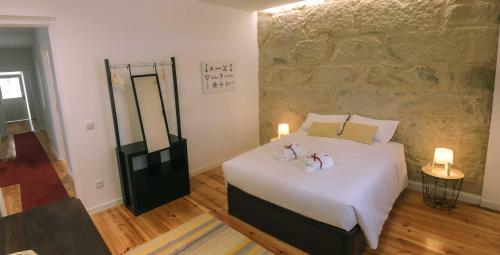 a bedroom with a bed with two stuffed animals on it at Siglas & Runas in Póvoa de Varzim