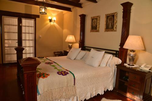 Un dormitorio con una cama y un teléfono en una mesa. en Villa Vicuña Wine & Boutique Hotel en Cafayate