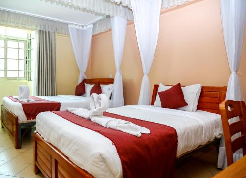 1 dormitorio con 2 camas con sábanas rojas y blancas en Decasa Hotel, en Nairobi
