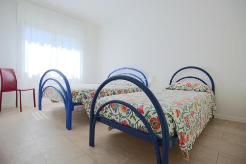 a bedroom with a bed with a floral bedspread at Residence Braida in Caorle