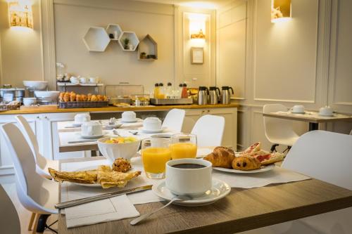 a breakfast table with coffee and croissants and orange juice at Best Western Montcalm in Paris