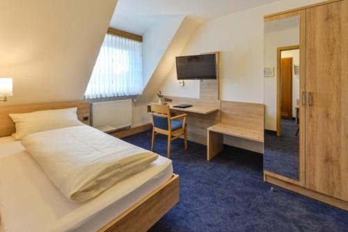 HeroldsbergにあるHotel-Gasthof Rotes Roßのベッドとデスクが備わるホテルルームです。