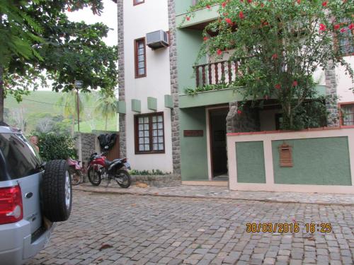 twee motorfietsen geparkeerd voor een gebouw bij Pousada Beija Flor in Cambuci