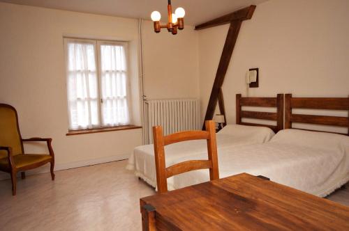 ブルボンヌ・レ・バンにあるRésidence PLEIN SOLEILのベッドルーム1室(ベッド1台、テーブル、椅子付)