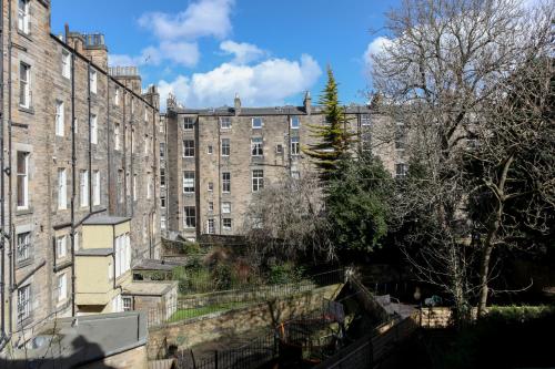 エディンバラにあるWest End Hotelの木々のある大きなレンガ造りの建物を望む