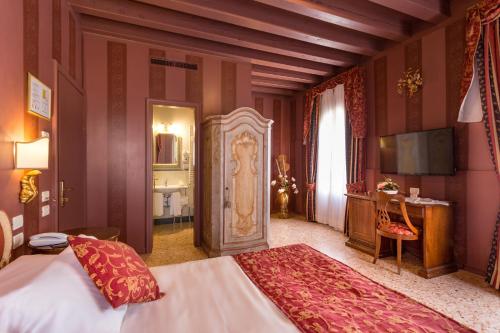 a bedroom with a bed and a desk and a television at Hotel Tiziano in Venice