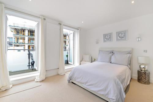 a white bedroom with a bed and a window at Tower Bridge Lux-Townhouse in London