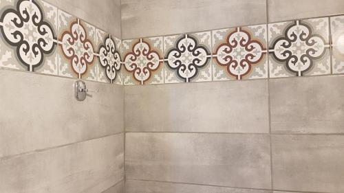 a bathroom with a shower with a tile wall at Erofili Rooms in Agia Galini