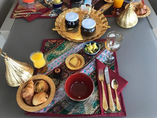 - une table recouverte de assiettes et de bols pour le petit-déjeuner dans l'établissement Cottages Domaine du Grand Bec, à Villerville