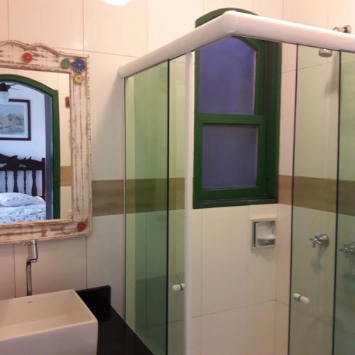 a bathroom with a sink and a glass shower at Pousada Sonho Meu in Paraty