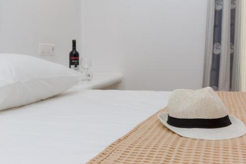 a straw hat sitting on top of a bed at Villa veranda in Plaka