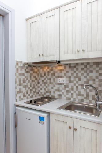 a kitchen with white cabinets and a sink at Villa veranda in Plaka