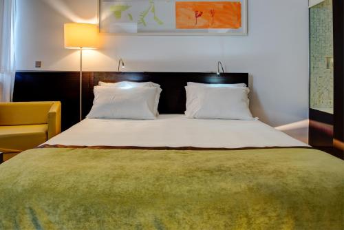 a bedroom with a large bed with a green blanket at VIP Grand Lisboa Hotel & Spa in Lisbon