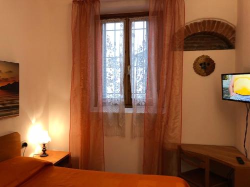 フィレンツェにあるLa Federigaの窓、ベッド、テレビが備わるベッドルーム1室が備わります。