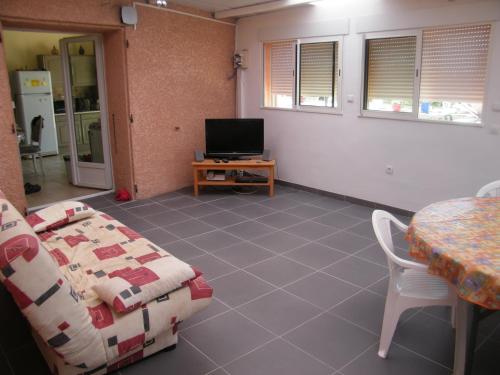een woonkamer met een tafel en een televisie bij La piscine in Fitou
