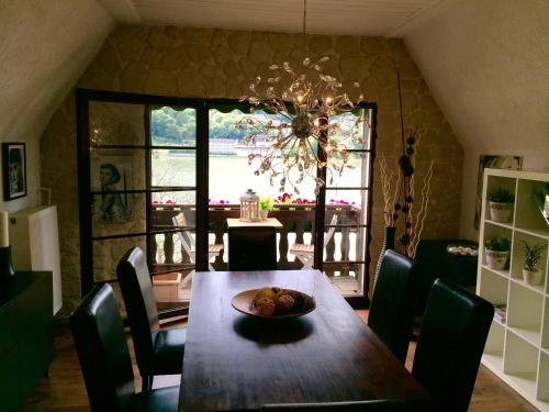 een eetkamer met een tafel met stoelen en een kroonluchter bij Villa Christina in Kamp-Bornhofen