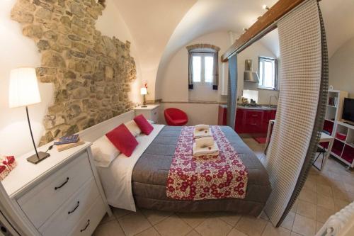 a bedroom with a bed and a stone wall at Il Convento sul Mare in Santo Stefano al Mare