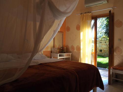 1 dormitorio con cama y ventana en Pension Aretoussa en Pitsidia