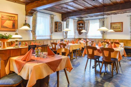 ein Restaurant mit Tischen und Stühlen in einem Zimmer in der Unterkunft Hotel-Gasthof Rotes Roß in Heroldsberg